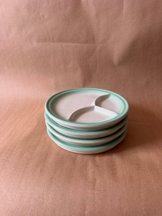 Stack of four mint green divided restaurant plates by Jackson China