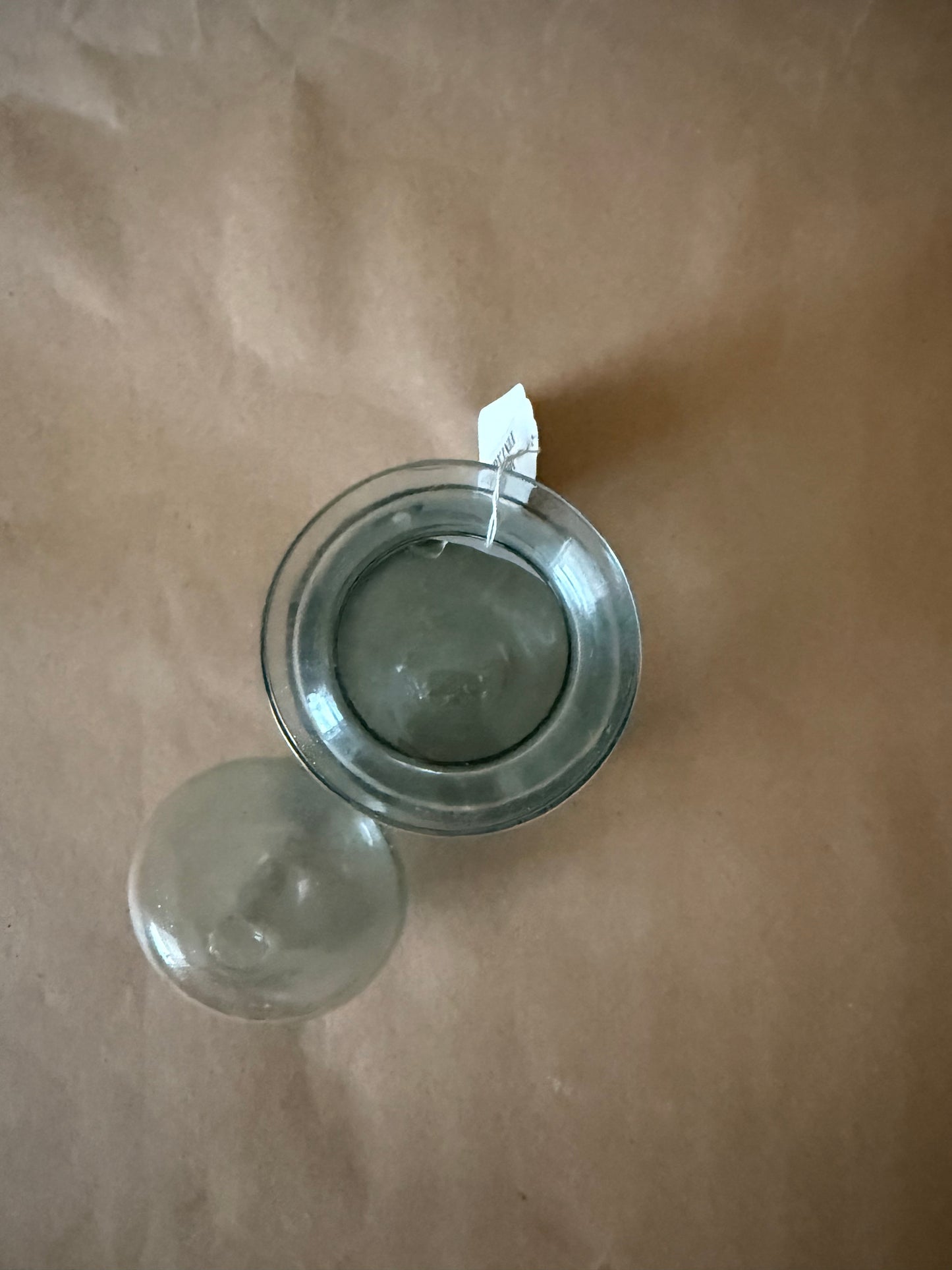 Overhead view of the open aqua glass jar and lid