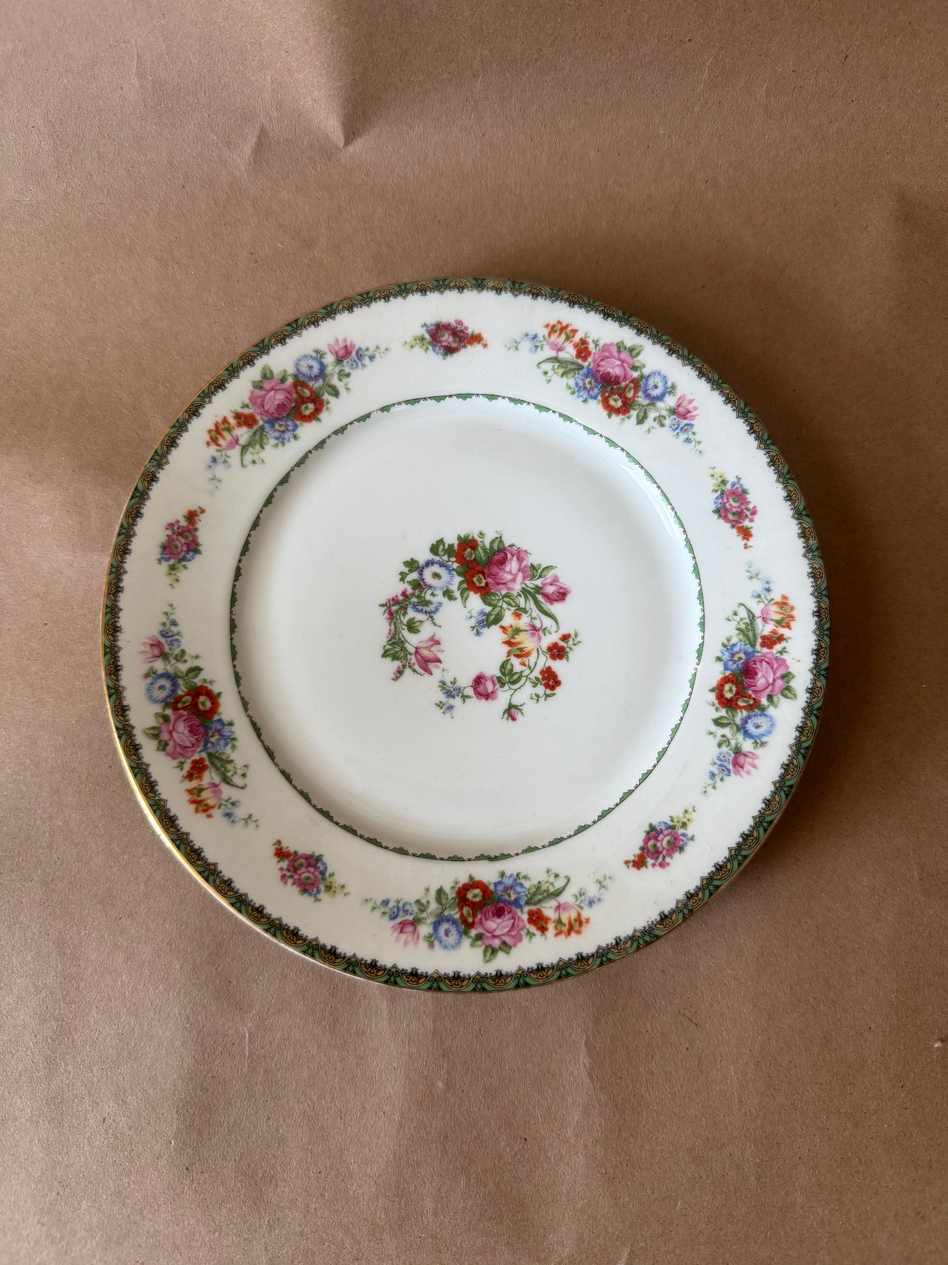 Floral porcelain plate with green scrolled border and gilt edge
