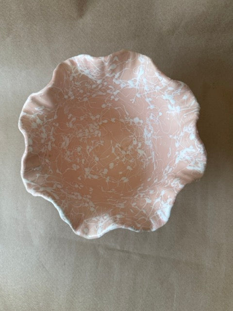 Pale pink ceramic bowl with white splatter glaze and ruffled rim