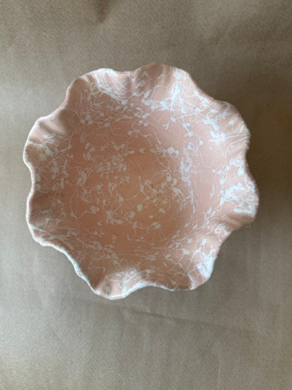 Pale pink ceramic bowl with white splatter glaze and ruffled rim