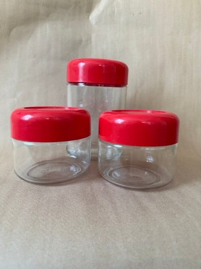 Set of three Heller glass canisters with red lids