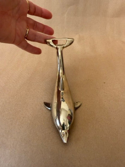 Dolphin opener, shown in hand for scale