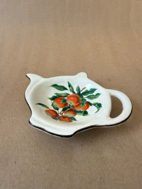 Teapot-shaped tea bag rest with persimmons