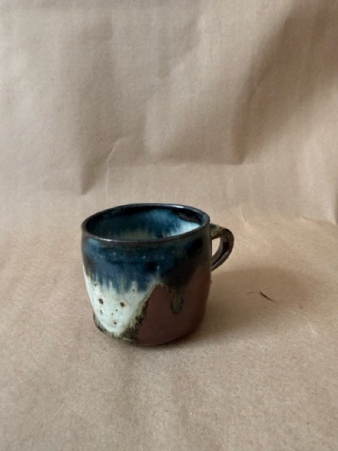Studio pottery mug with blue drip glaze