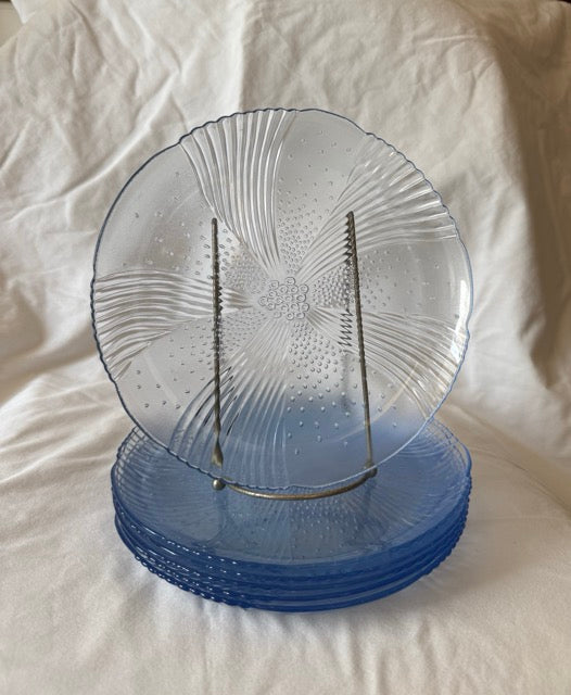 Blue swirl glass luncheon plate upright in front of the stacked set