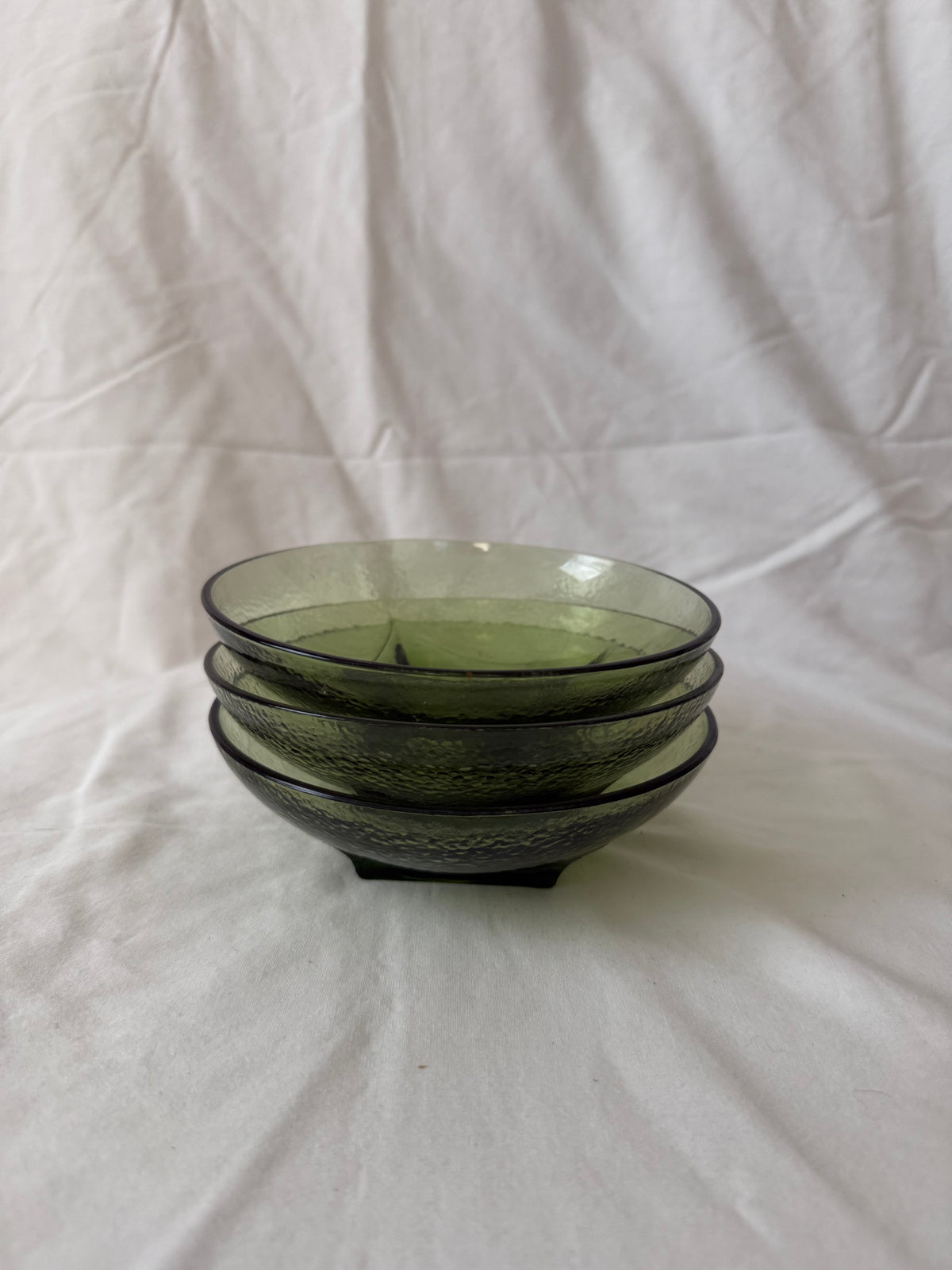 Three avocado green glass bowls, stacked