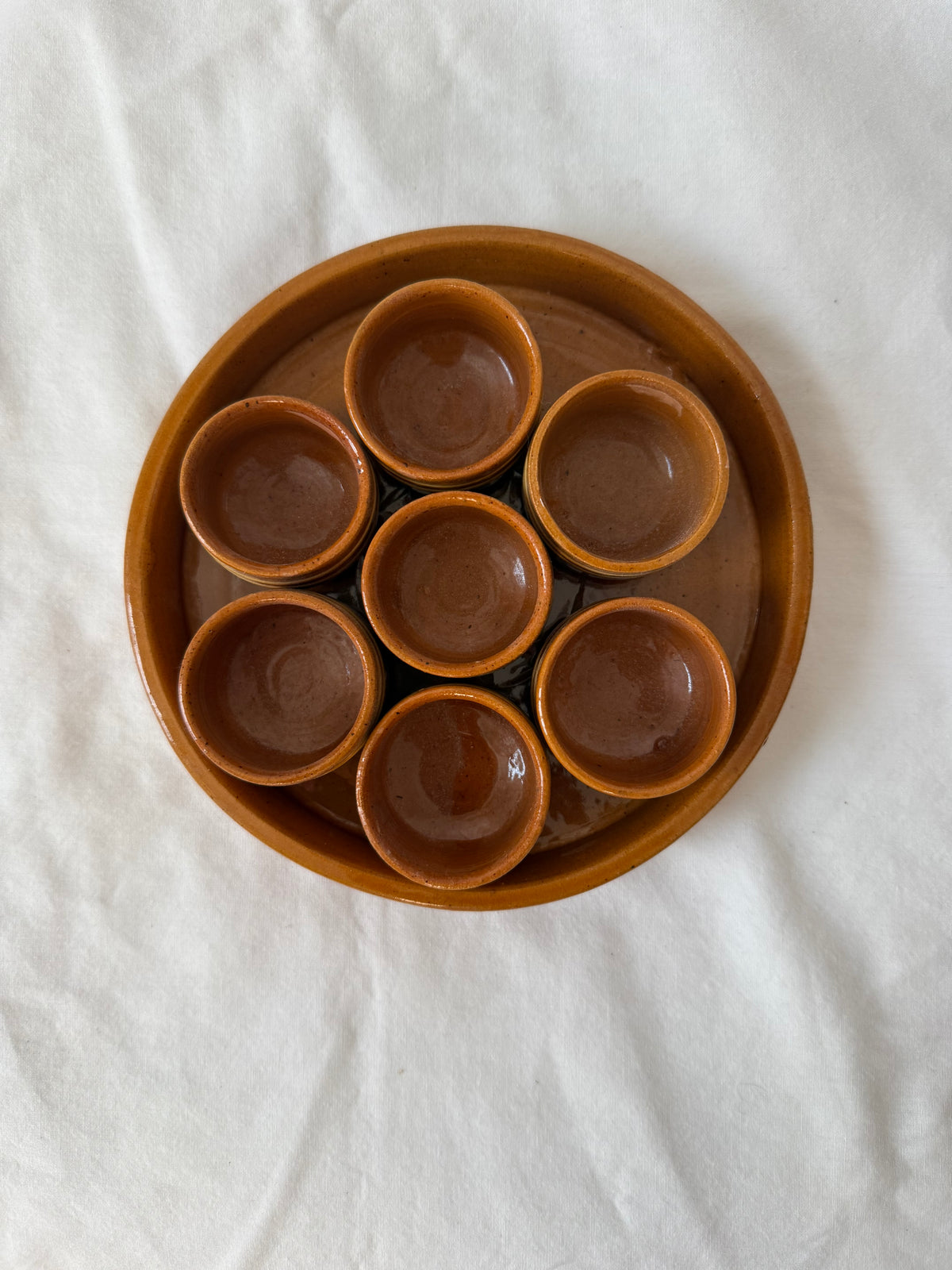 Stoneware tray with seven condiment cups, from above