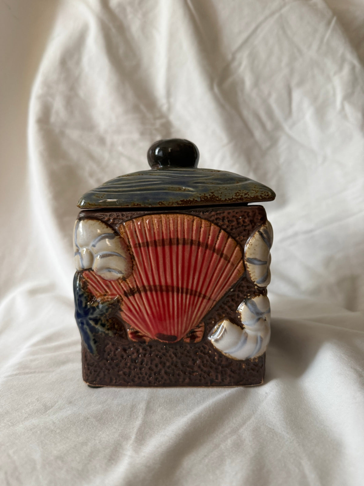 Side view showing a large red scallop shell in relief