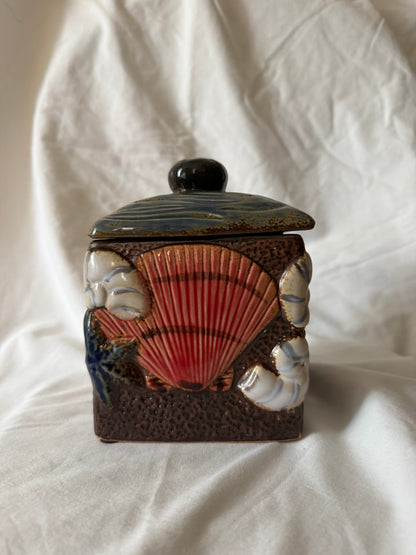 Side view showing a large red scallop shell in relief