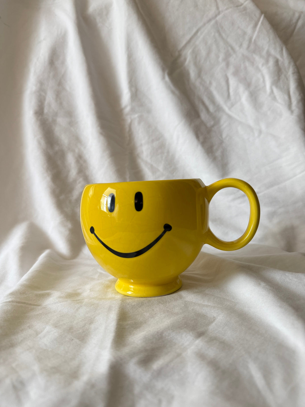 Yellow footed mug with a smiley face