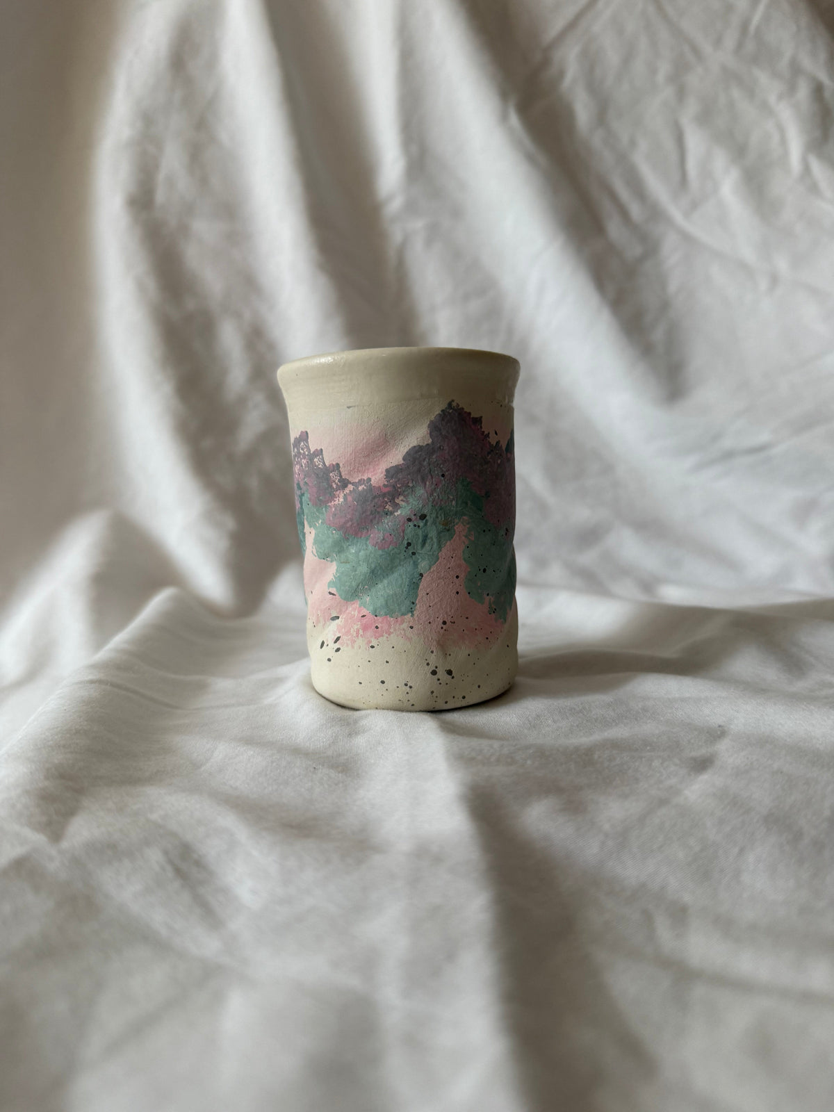 Speckled cream pottery tumbler with pink, teal and lavender band