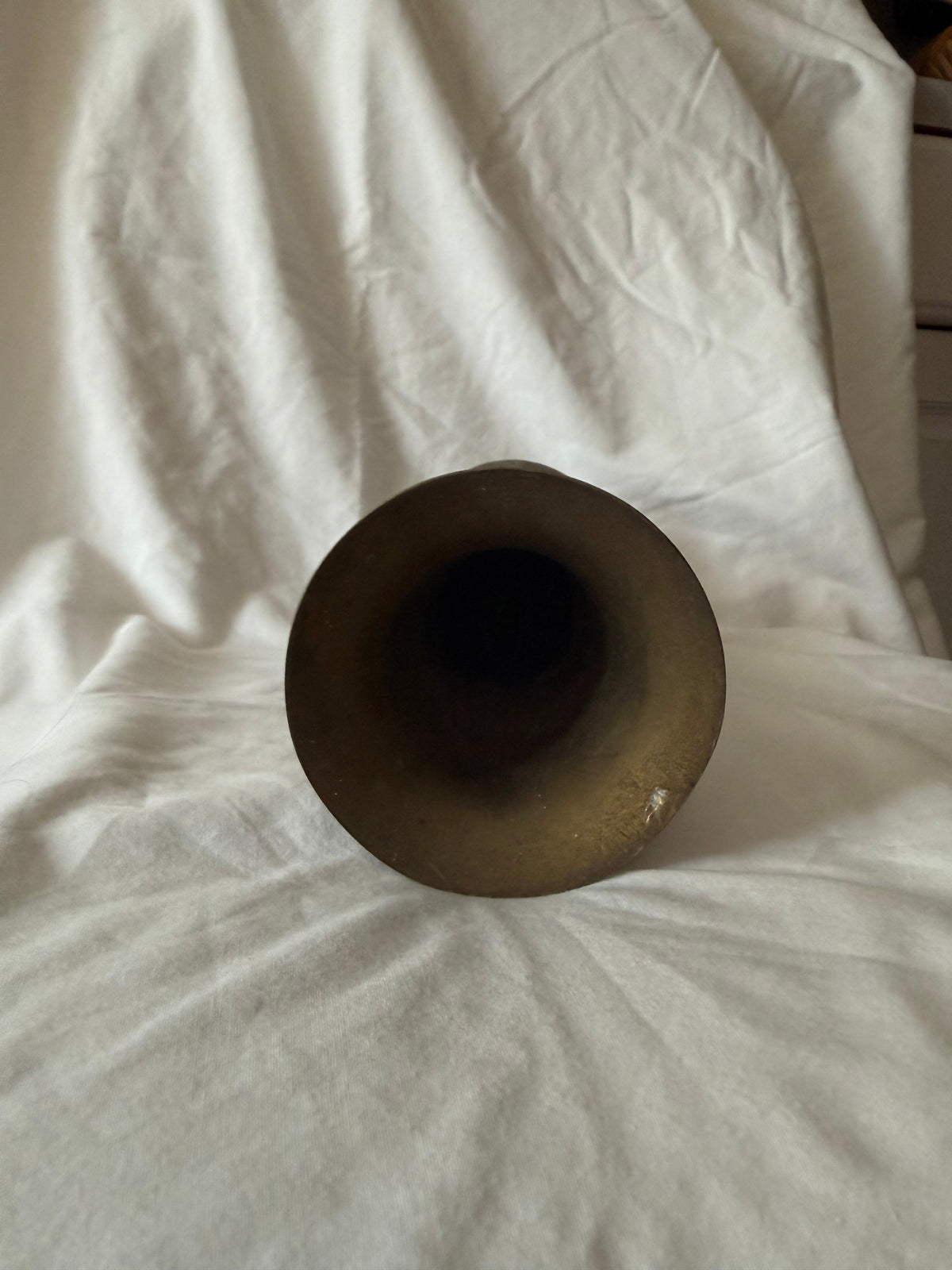 Flared rim of the brass vase with a small ding
