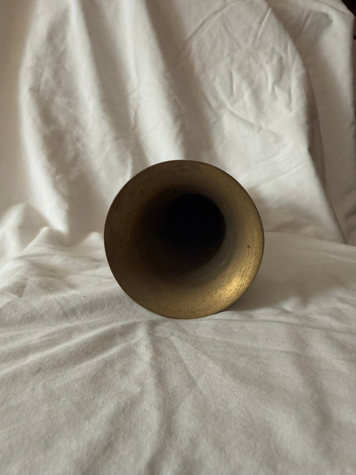 Flared rim of the etched brass vase