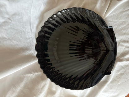 Black glass dish shaped like a scallop shell