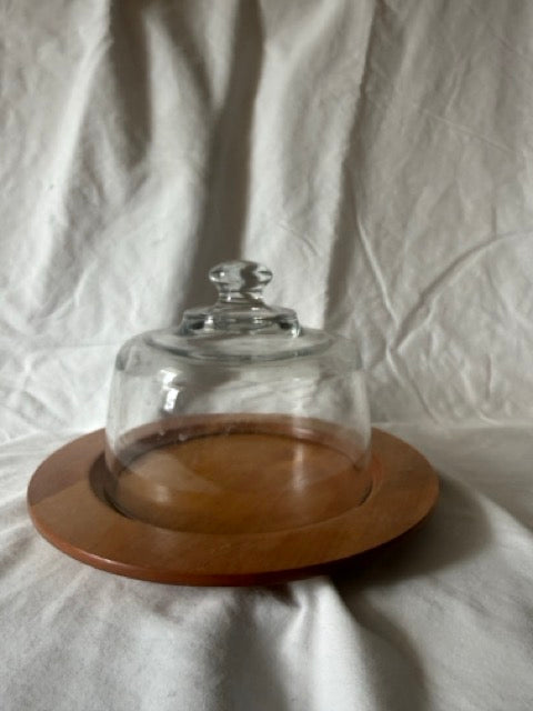 Glass cheese dome on round wood board