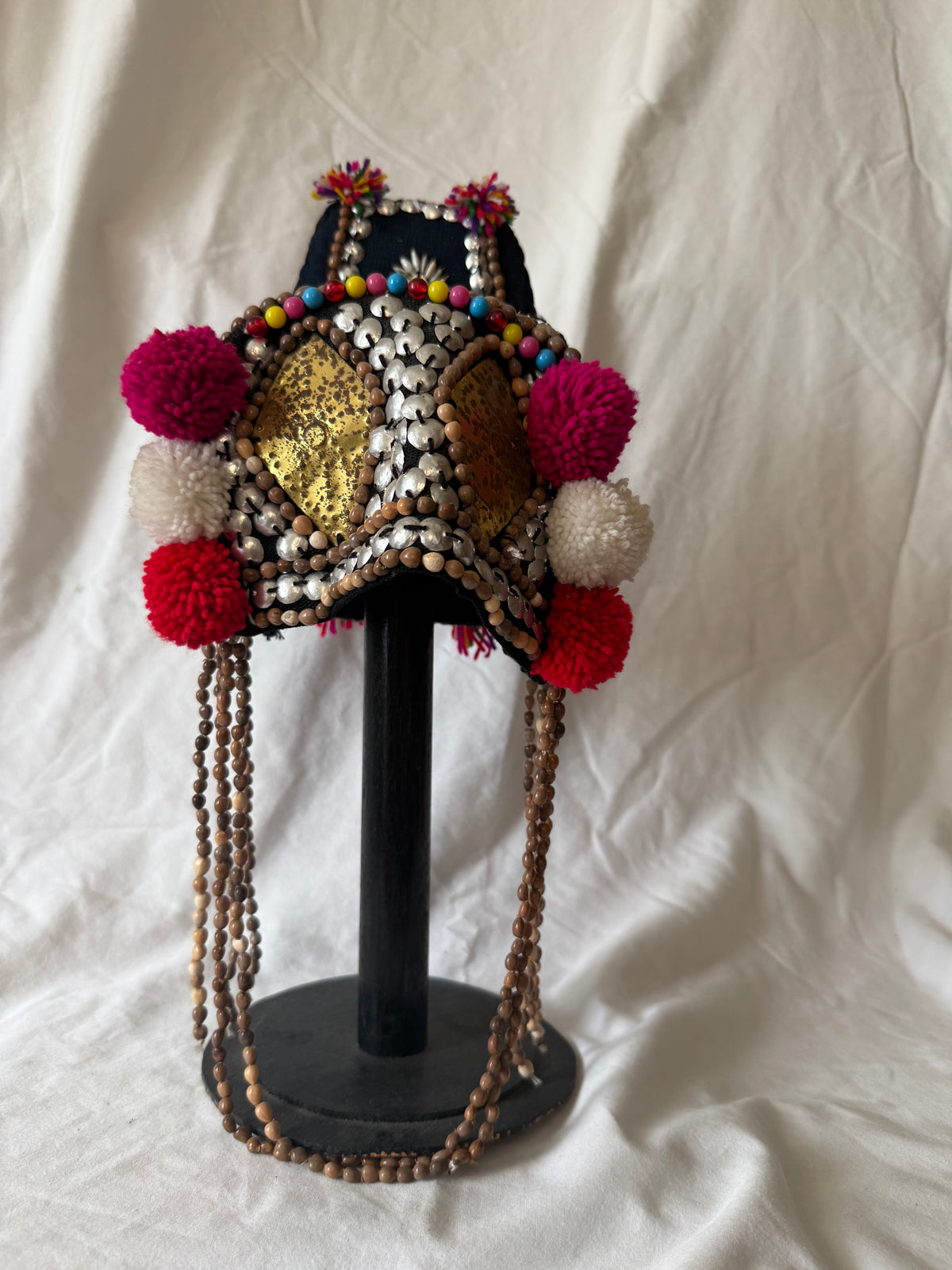 Akha-style beaded headdress with pom-poms